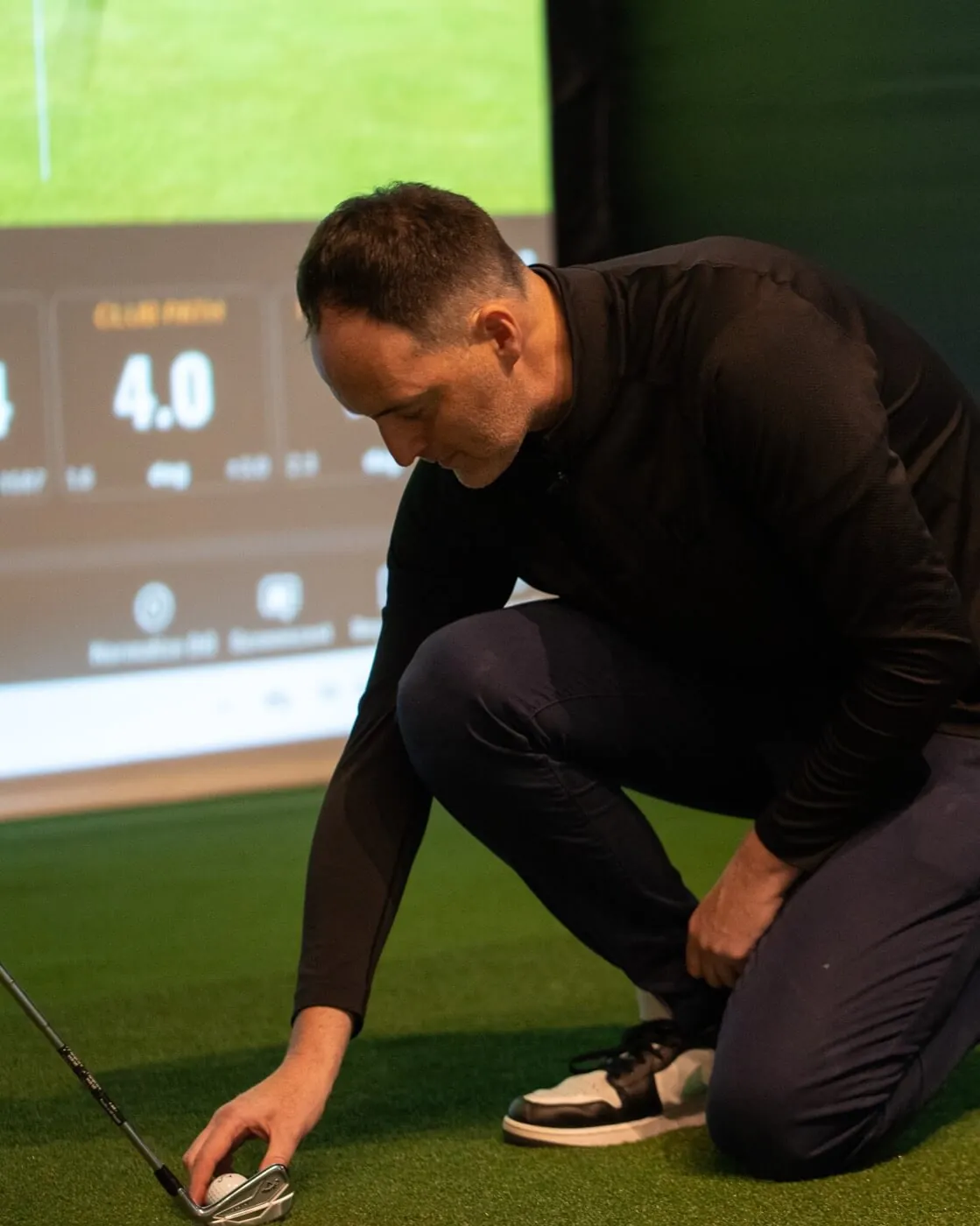 Mark Curtis coaching a golfer in a Trackman bay at Grip Golf